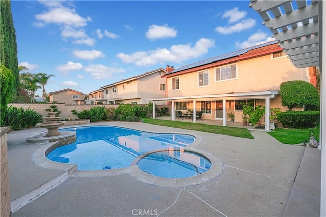 view of swimming pool with a pool with connected hot tub, fence private yard, and a patio area