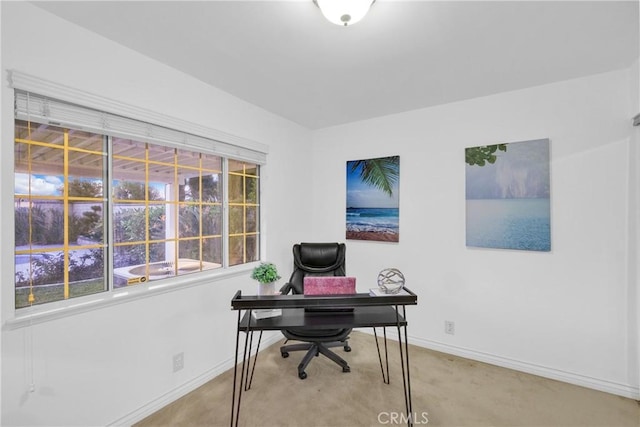 carpeted home office featuring baseboards