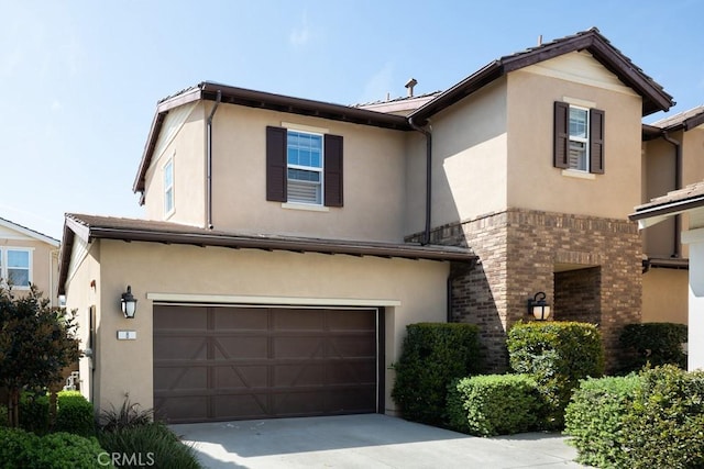 traditional home featuring driveway, stucco siding, an attached garage, and brick siding