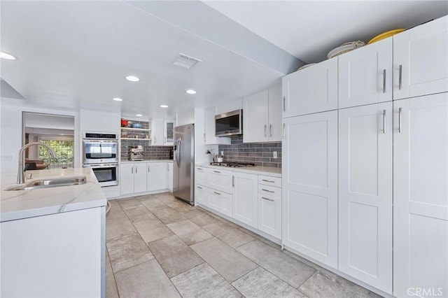 23163 Mulholland Dr Unit 6, Woodland Hills, CA 91364 - kitchen with stainless steel appliances, backsplash, white cabinets, light stone countertops, and recessed lighting