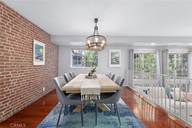 23163 Mulholland Dr Unit 6, Woodland Hills, CA 91364 - dining room featuring brick wall, wood finished floors, a chandelier, healthy amount of natural light, and an accent wall