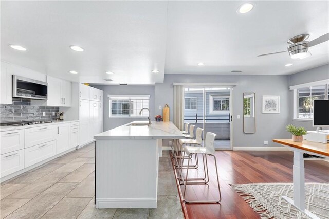 23163 Mulholland Dr Unit 6, Woodland Hills, CA 91364 - kitchen featuring a breakfast bar area, white cabinets, recessed lighting, decorative backsplash, and stainless steel appliances