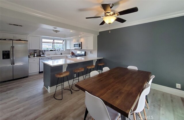 2512 Santa Ana Ave Unit 9, Costa Mesa, CA 92627 - dining area with crown molding, a ceiling fan, light wood finished floors, and baseboards
