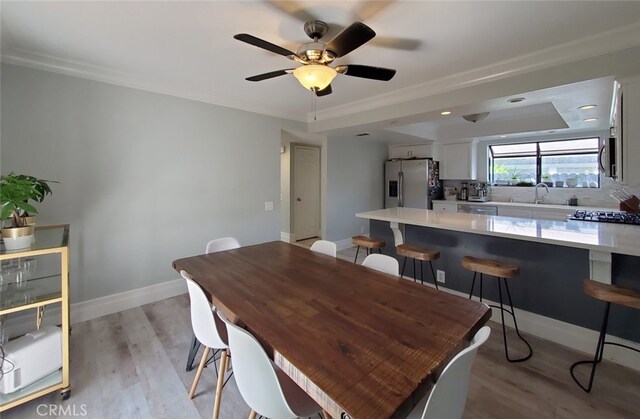 2512 Santa Ana Ave Unit 9, Costa Mesa, CA 92627 - dining room with light wood-type flooring, a ceiling fan, baseboards, and crown molding