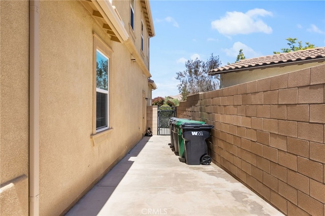34595 Collier Falls Ct, Temecula, CA 92592 - view of side of home featuring stucco siding and a gate