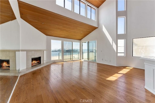 unfurnished living room with wood ceiling, plenty of natural light, hardwood / wood-style flooring, and a fireplace