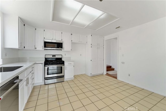 kitchen featuring light countertops, a sink, visible vents, white cabinets, and appliances with stainless steel finishes