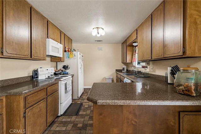 295 Chestnut Ave, Red Bluff, CA 96080 - kitchen featuring a sink, brown cabinetry, visible vents, white appliances, and dark countertops