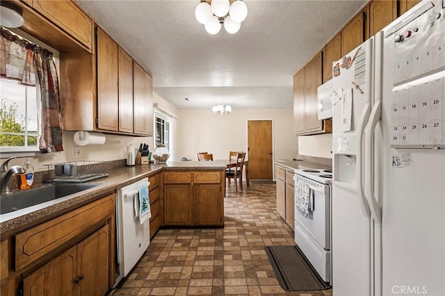 295 Chestnut Ave, Red Bluff, CA 96080 - kitchen featuring white appliances, an inviting chandelier, a sink, a peninsula, and brown cabinets
