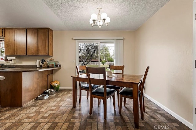 295 Chestnut Ave, Red Bluff, CA 96080 - dining space with baseboards, brick floor, a textured ceiling, and an inviting chandelier
