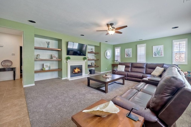 1140 Parkview Dr, Oceanside, CA 92057 - living area with ceiling fan, built in features, a warm lit fireplace, light tile patterned flooring, and baseboards