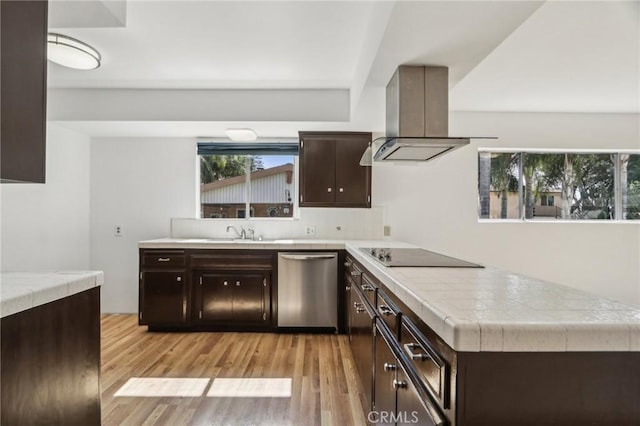kitchen featuring light wood-style floors, island exhaust hood, black electric stovetop, dark brown cabinetry, and stainless steel dishwasher