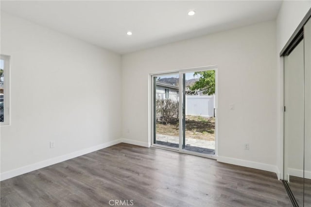 interior space featuring recessed lighting, wood finished floors, and baseboards