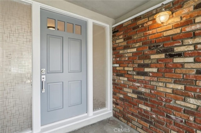view of exterior entry featuring brick siding