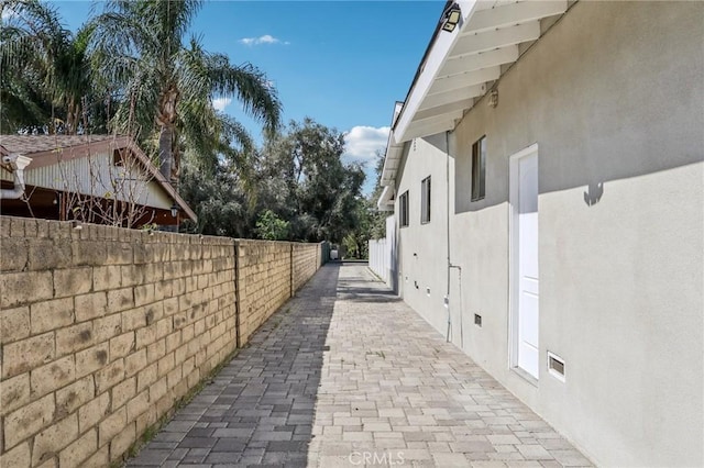 view of property exterior with stucco siding and fence