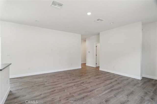 spare room featuring baseboards, visible vents, and light wood-style floors