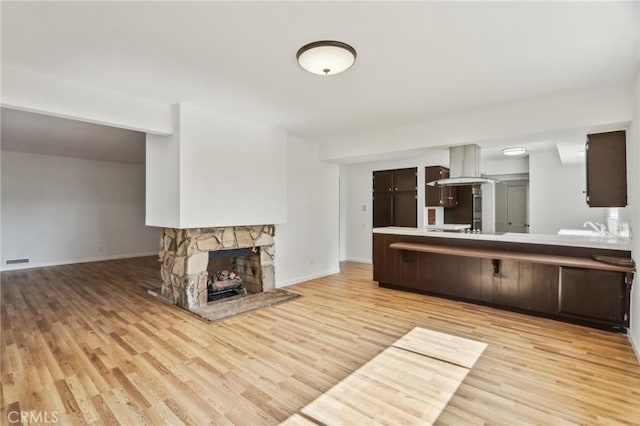 interior space with baseboards, visible vents, a fireplace, and light wood-style flooring