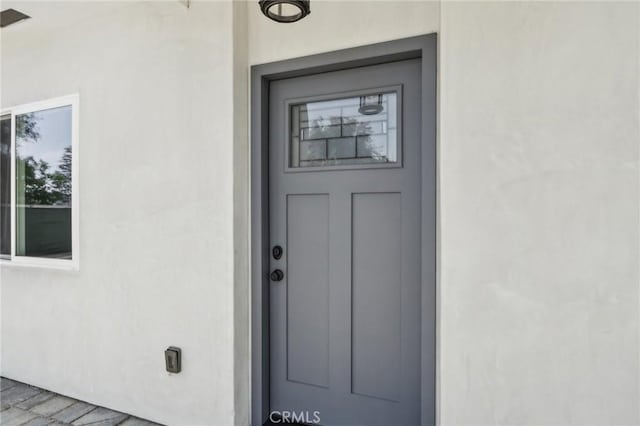 doorway to property featuring stucco siding