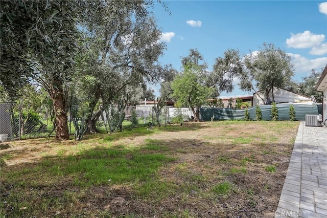 view of yard with fence and central air condition unit