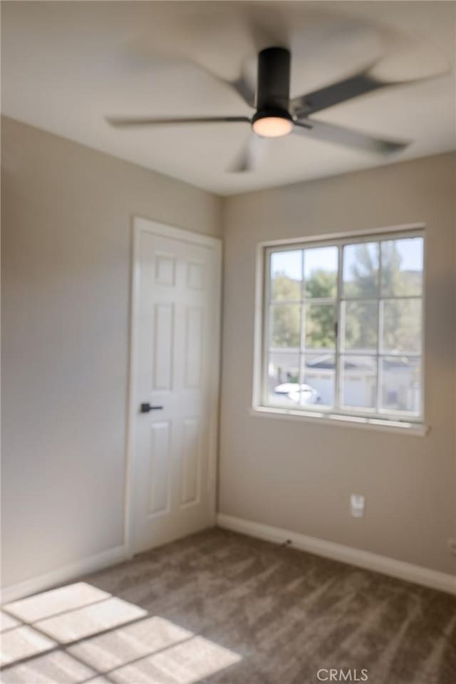 unfurnished bedroom with ceiling fan, carpet flooring, and baseboards