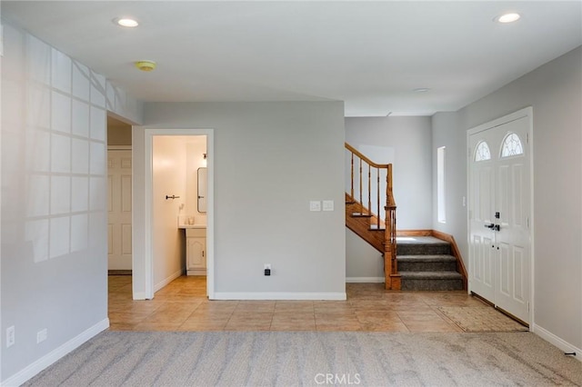 entryway with recessed lighting, baseboards, tile patterned flooring, and stairway