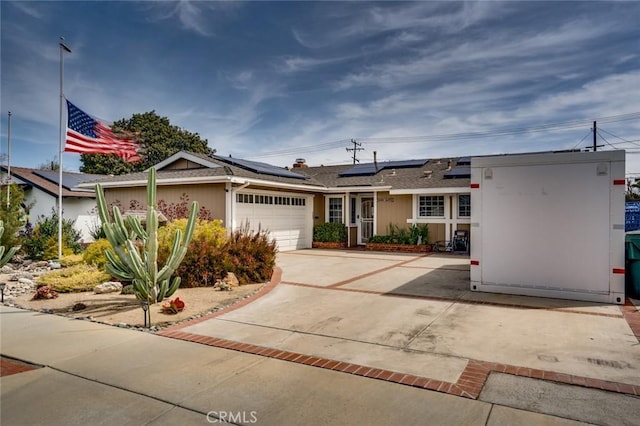 16372 Hollywood Ln, Huntington Beach, CA 92649 - ranch-style house with solar panels, an attached garage, a shingled roof, and driveway
