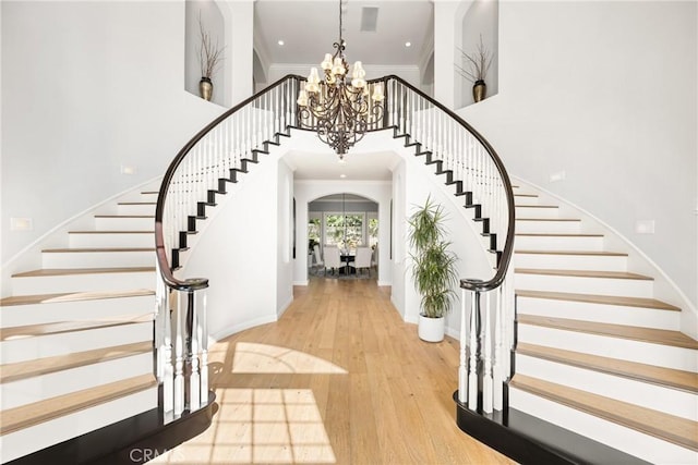 2107 Lemon Heights Dr, Santa Ana, CA 92705 - entrance foyer with stairway, arched walkways, a chandelier, and light wood-style floors