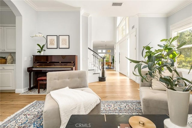 2107 Lemon Heights Dr, Santa Ana, CA 92705 - living room featuring ornamental molding, visible vents, light wood-style flooring, and stairway