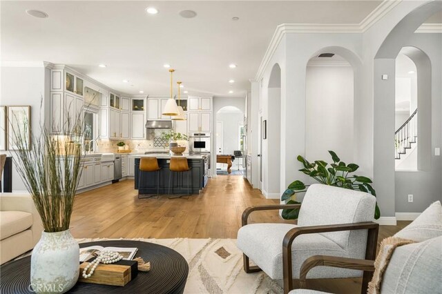 2107 Lemon Heights Dr, Santa Ana, CA 92705 - living room featuring crown molding, recessed lighting, stairs, light wood finished floors, and baseboards
