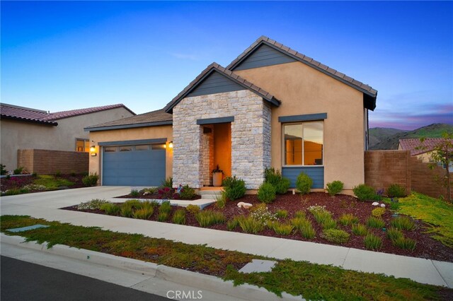24128 Rimstone Dr, Corona, CA 92883 - view of front facade featuring a garage, stucco siding, fence, stone siding, and driveway
