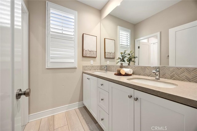 bathroom with double vanity, a sink, and decorative backsplash