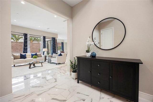 corridor featuring baseboards, recessed lighting, and marble finish floor