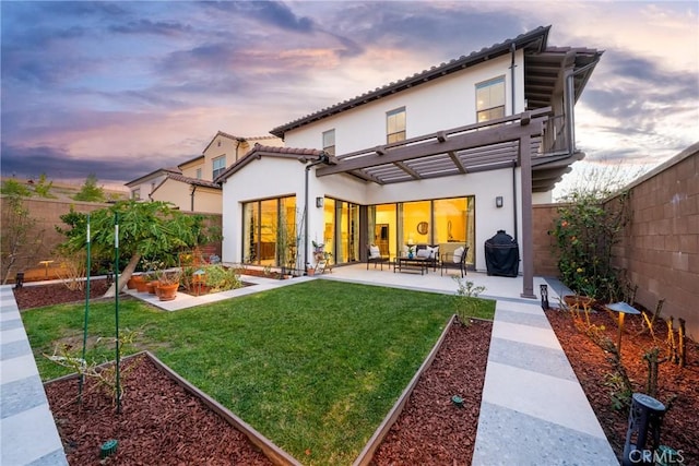 back of house at dusk featuring outdoor lounge area, a patio, a fenced backyard, and stucco siding