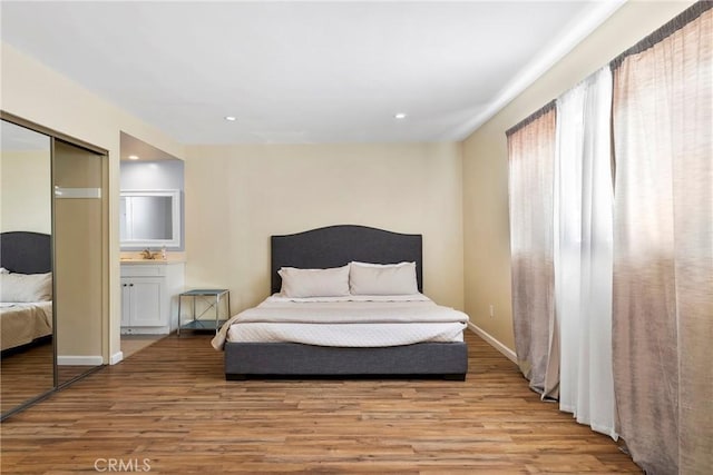 bedroom featuring baseboards, a closet, wood finished floors, and recessed lighting