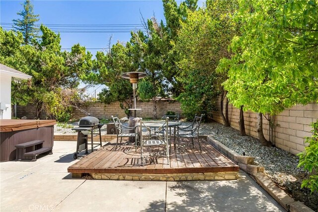 view of patio / terrace with a fenced backyard, outdoor dining area, area for grilling, and a hot tub