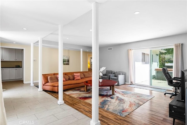 living room with light wood finished floors, baseboards, visible vents, and recessed lighting