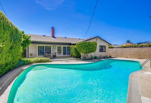 view of pool with a patio area, french doors, fence, and a fenced in pool