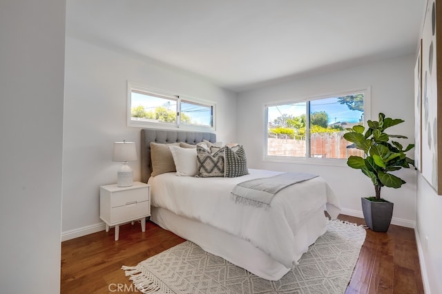 bedroom with baseboards and wood finished floors
