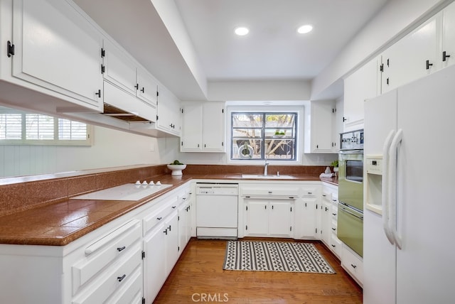 kitchen with a warming drawer, white appliances, plenty of natural light, and a sink