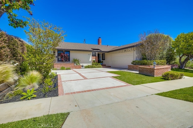 view of front of house with a front yard, an attached garage, a chimney, concrete driveway, and brick siding