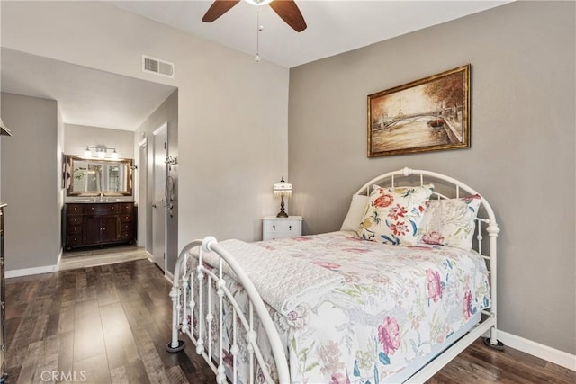 bedroom with a sink, baseboards, visible vents, wood finished floors, and ensuite bath