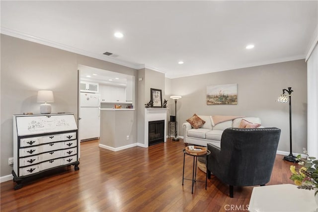 living area with visible vents, baseboards, recessed lighting, ornamental molding, and dark wood finished floors