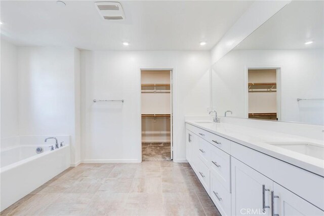 972 W Jasmine Way, Rialto, CA 92376 - bathroom featuring a spacious closet, recessed lighting, double vanity, and a bath
