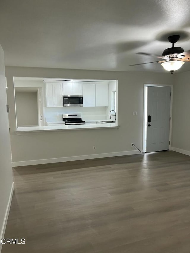 391 N 9th St, Blythe, CA 92225 - kitchen featuring light countertops, wood finished floors, baseboards, appliances with stainless steel finishes, and white cabinetry