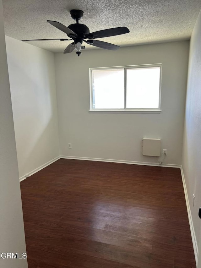 391 N 9th St, Blythe, CA 92225 - empty room featuring a ceiling fan, a textured ceiling, dark wood-type flooring, and a healthy amount of sunlight