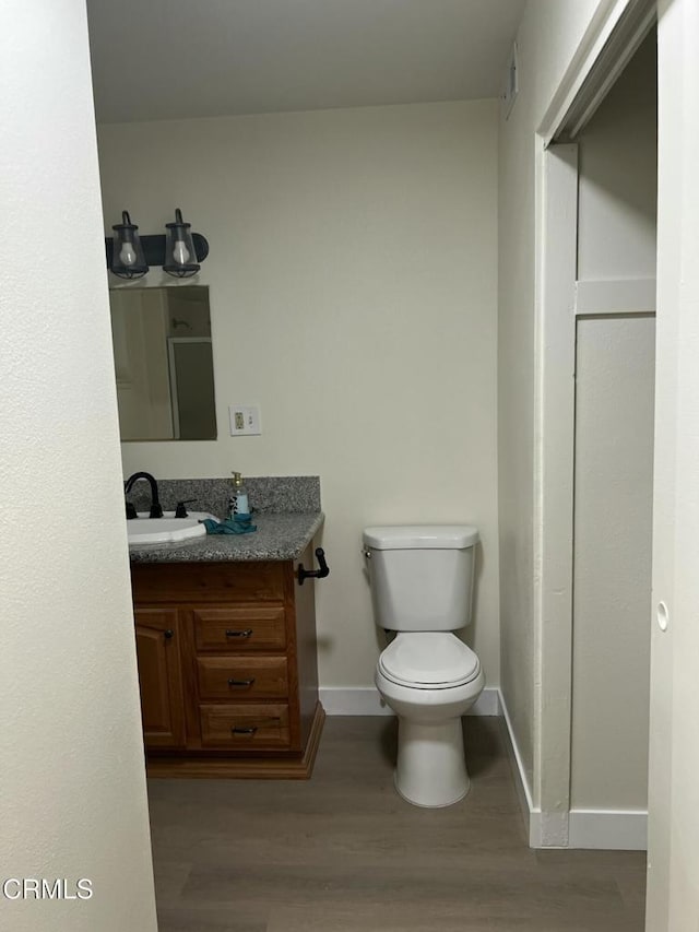 391 N 9th St, Blythe, CA 92225 - bathroom with toilet, wood finished floors, vanity, and baseboards