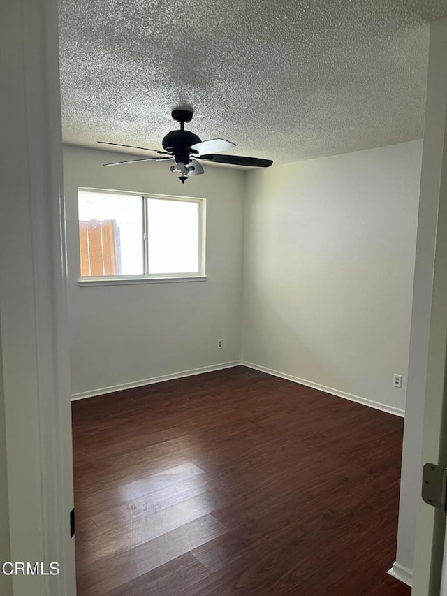 391 N 9th St, Blythe, CA 92225 - empty room with dark wood-style flooring, a ceiling fan, a textured ceiling, and baseboards