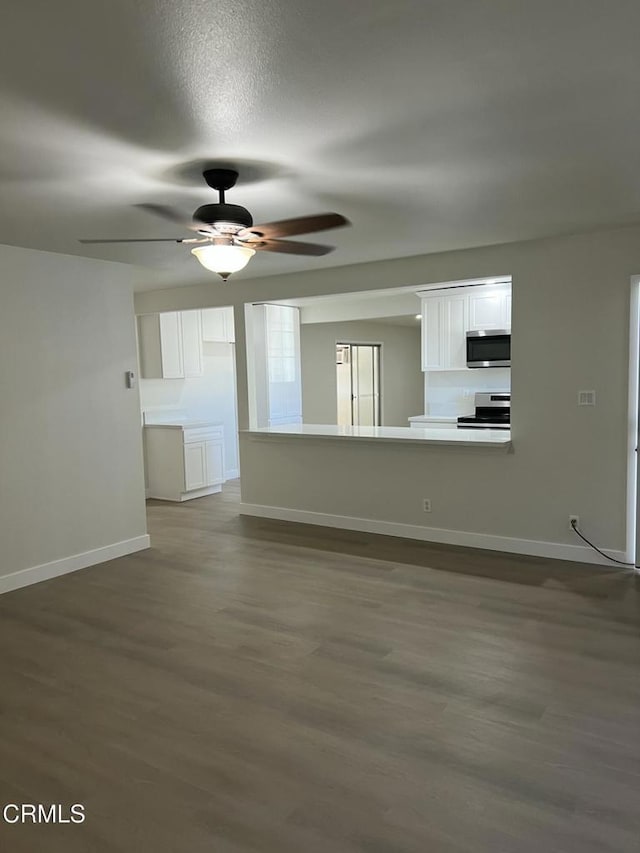 391 N 9th St, Blythe, CA 92225 - unfurnished living room featuring a ceiling fan, baseboards, and dark wood-style flooring