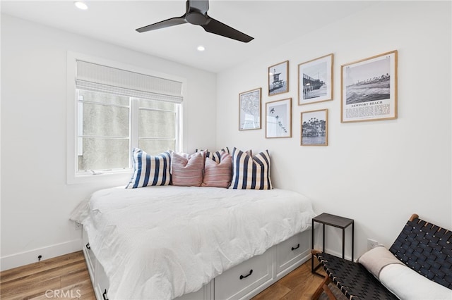 bedroom with recessed lighting, wood finished floors, and baseboards