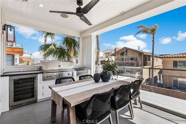 view of patio with an outdoor kitchen, a ceiling fan, beverage cooler, grilling area, and outdoor dining area